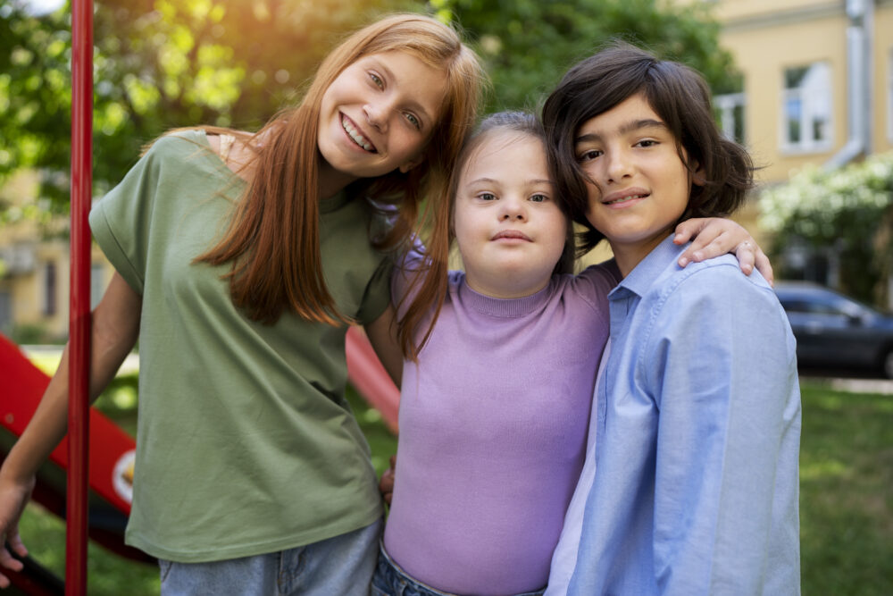 Three children standing together outdoors.