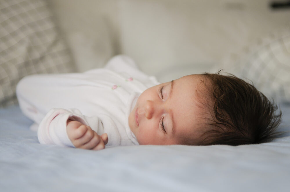 Sleeping baby lying on a bed.