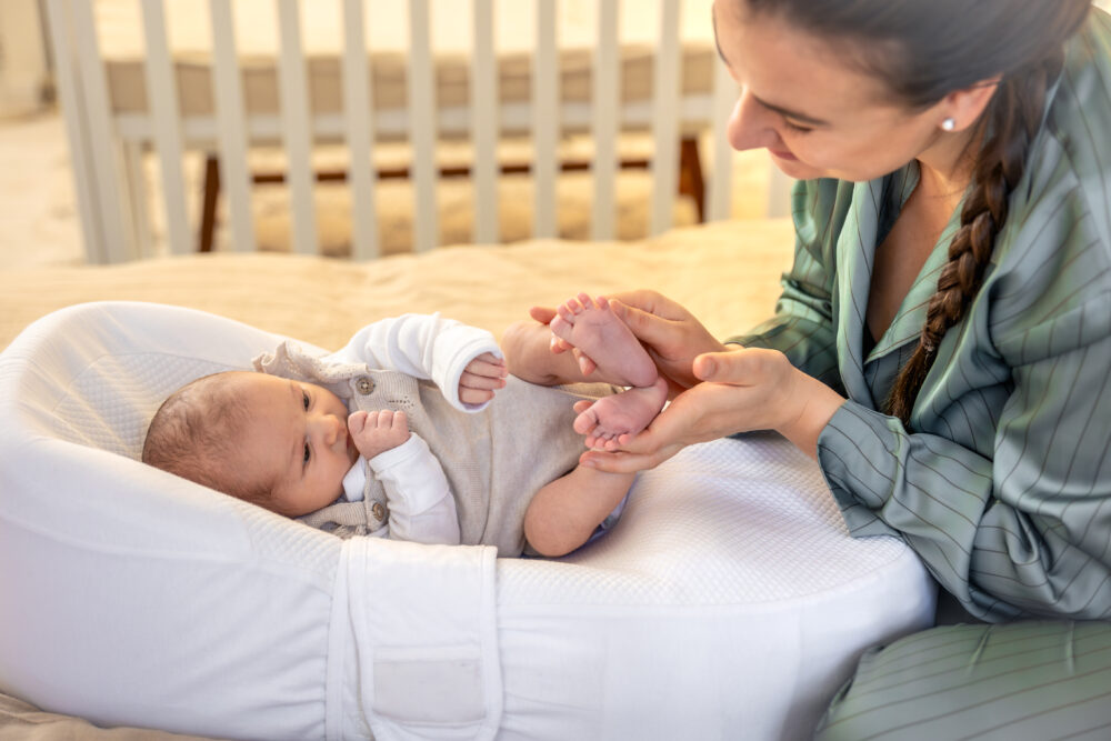 Adult holding a baby’s feet during a nappy change.