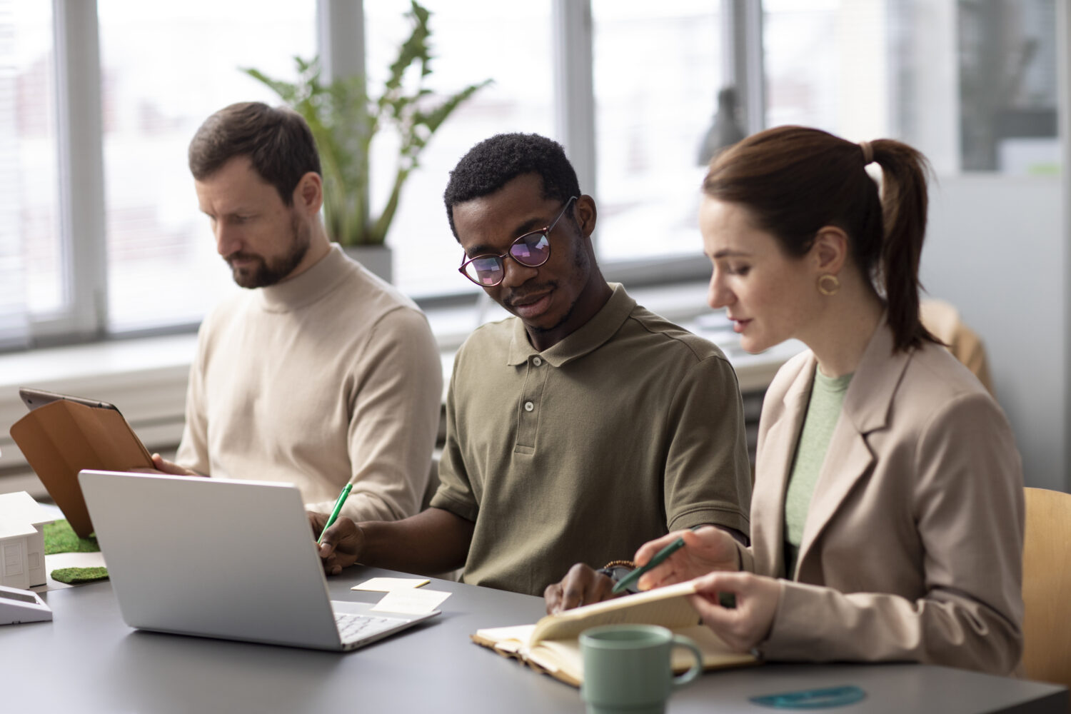 People around a table looking at research on a laptop