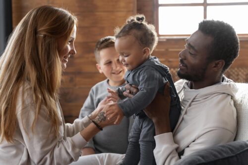 Smiling family holding baby